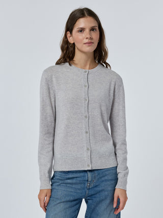 Woman wearing a gray cardigan and blue jeans on a light gray background Smoke