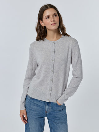 Woman wearing a gray cardigan and blue jeans on a white background Smoke