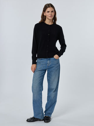 Person wearing a black cardigan and blue jeans on a white background Black