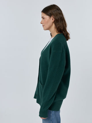 Woman wearing a green cardigan against a white background Hunter