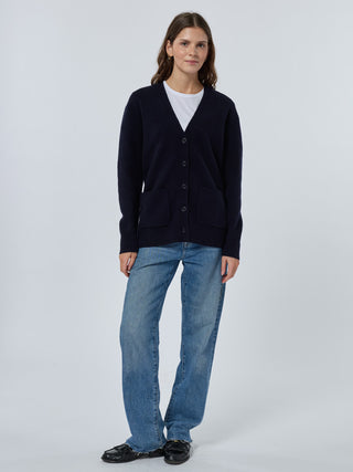 Woman wearing a cardigan, white shirt, blue jeans, and black shoes on a white background Navy