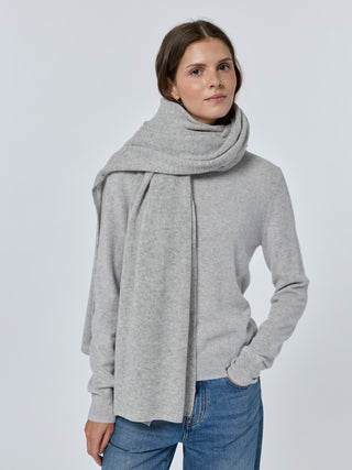 Woman wearing a gray scarf and sweater with a plain background Smoke